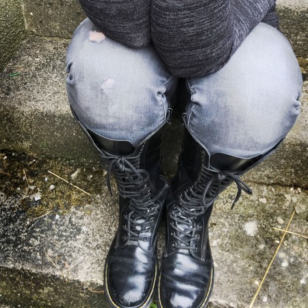 Dr Martens boots and the image of a woman with elbows on her knees showing anxiety